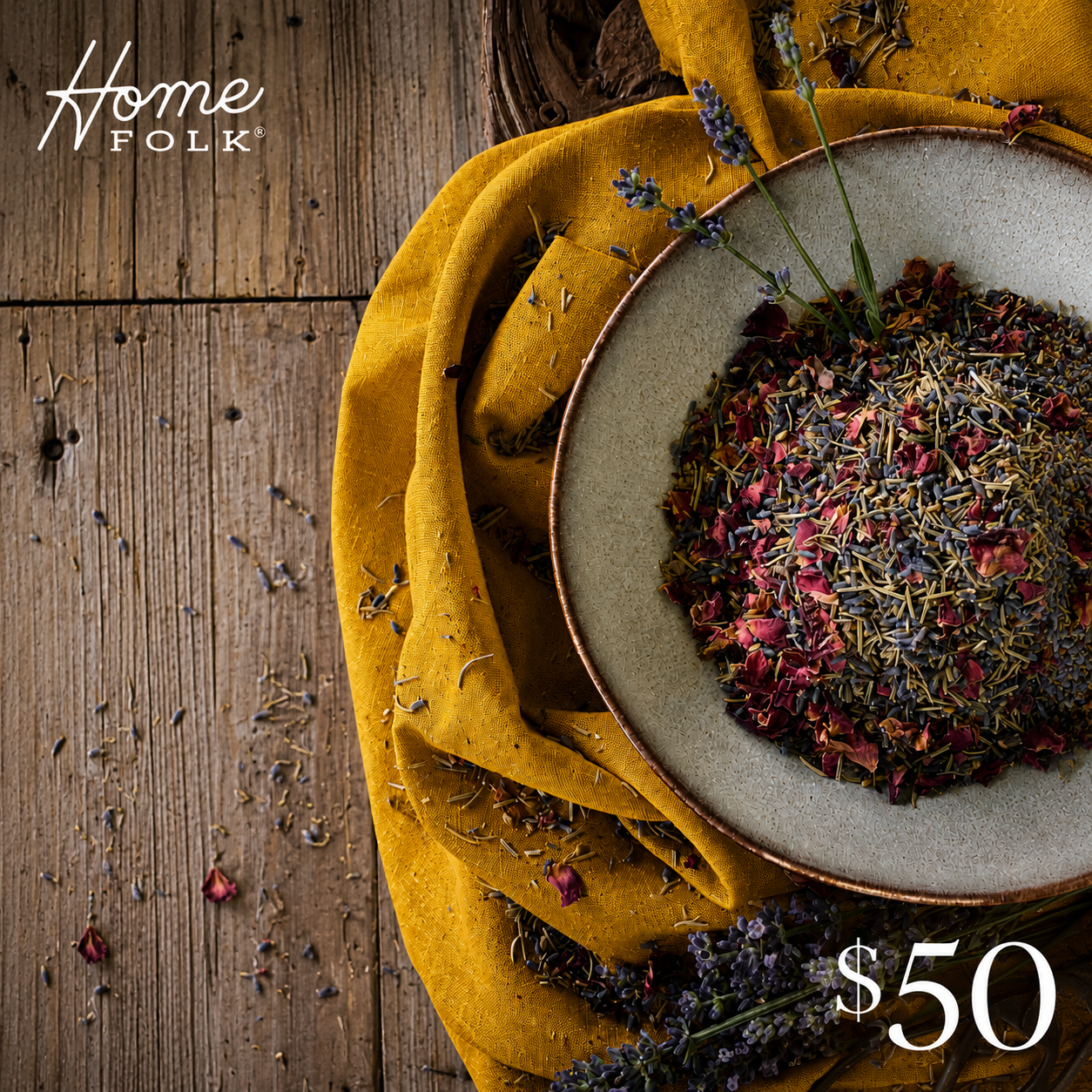 A bowl of loose floral, dried botanicals rests on a yellow linen towel on a wooden surface. $50 written in lower right corner.