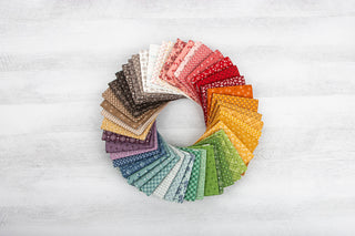 Folded fabric from the Calico Collection placed in a circle on a white background.