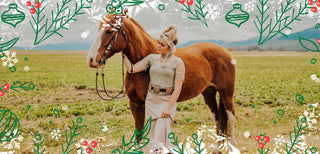 A woman stands in front of a silo and train tracks. She wears a white top with mustard and white striped flare jeans.