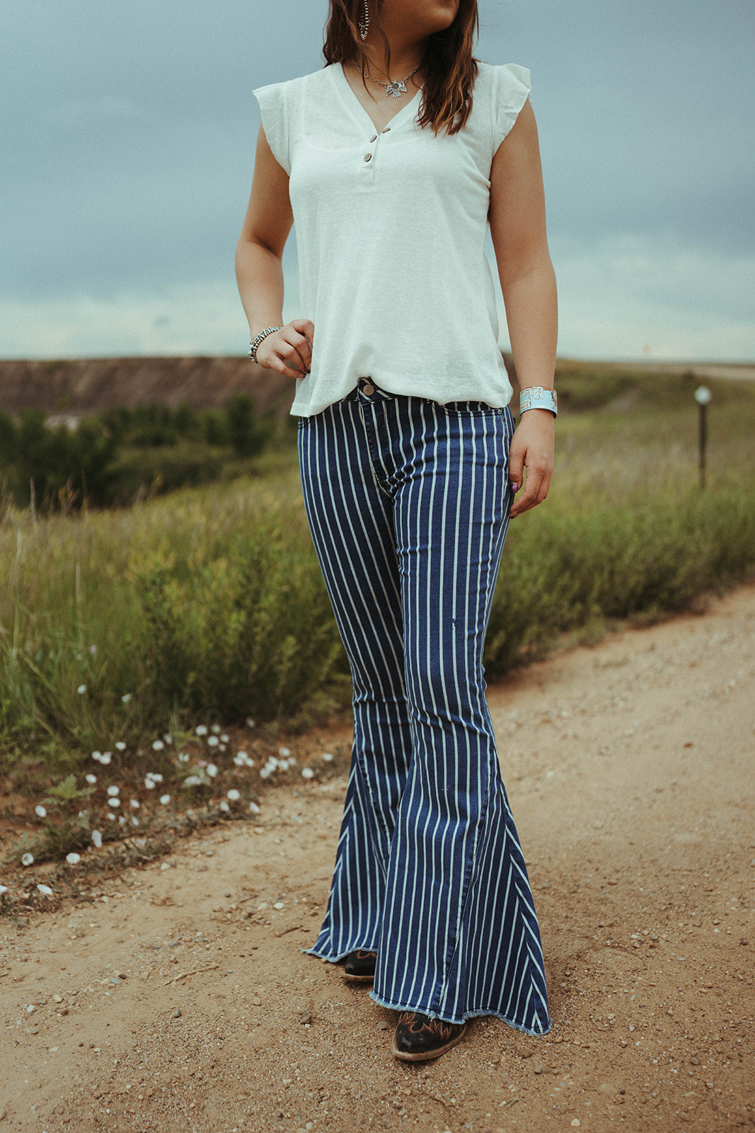 Woman standing on dirt road wearing the Home Fold brand Stripe Flares.  Blue & white stripe. 