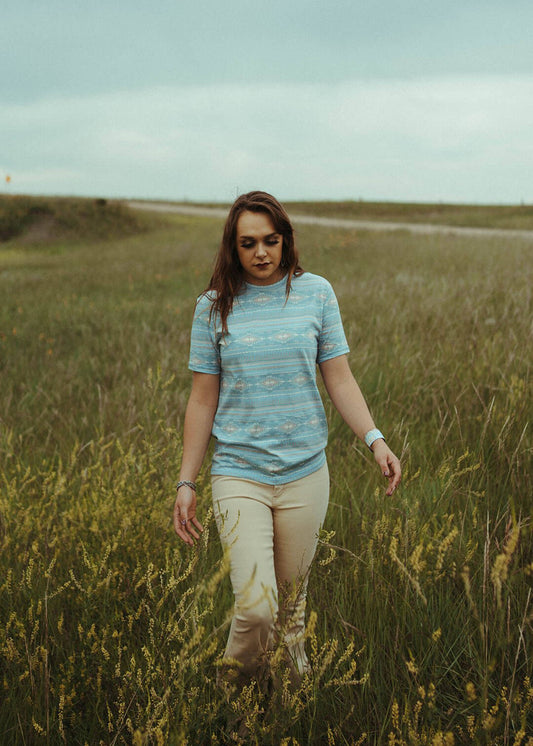 Woman standing in field modeling the All Over Print Tee in Aqua by Rock & Roll Denim.
