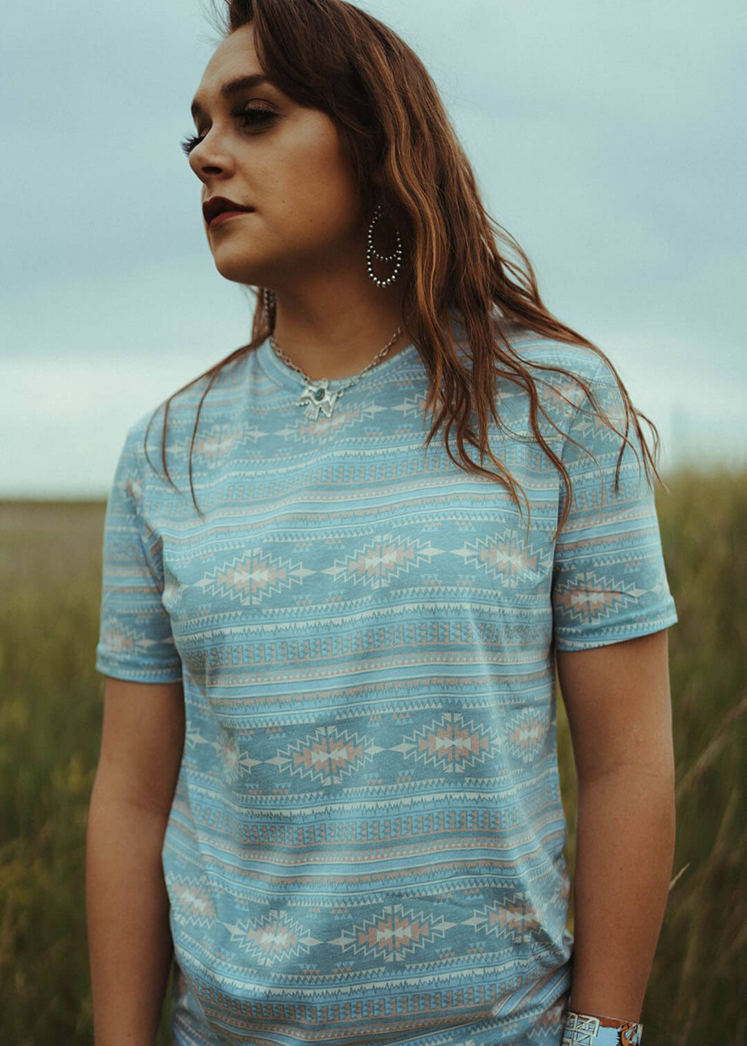 Woman modeling the All Over Print Tee in Aqua by Rock & Roll Denim.  Unisex shirt.  