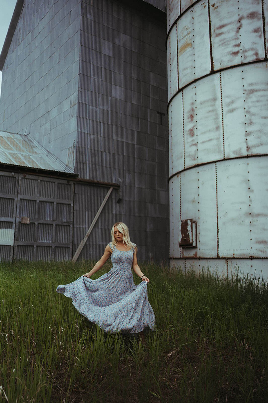 Woman standing in Tall Grass modeling the Floral Tiered Maxi Dress by Rock & Roll Denim.