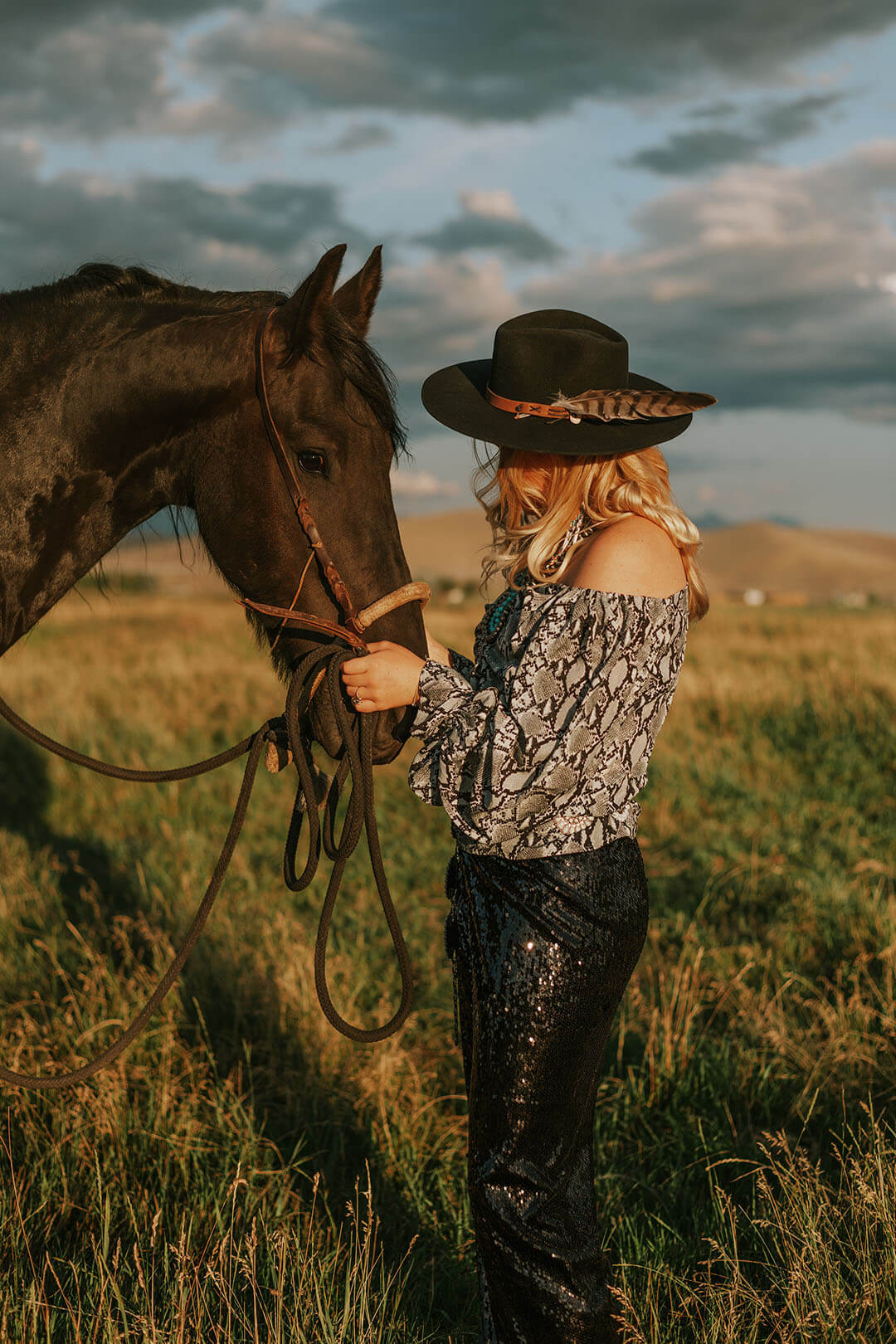 Woman standing in front of horse holding the reigns modeling the TeePee Black Cowgirl Hat.