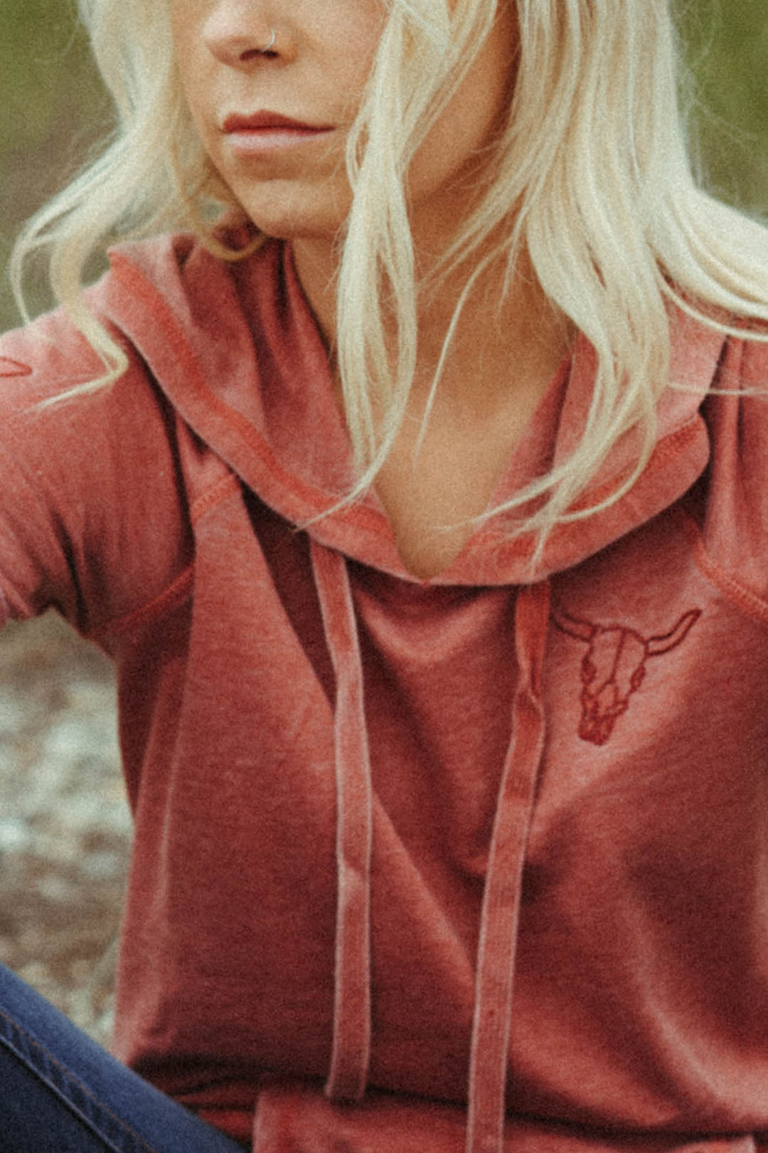 Close up image of the Short Sleeve Embroidered Hoodie with Cowskull embroidered on left side of shirt.  Red color shirt. 