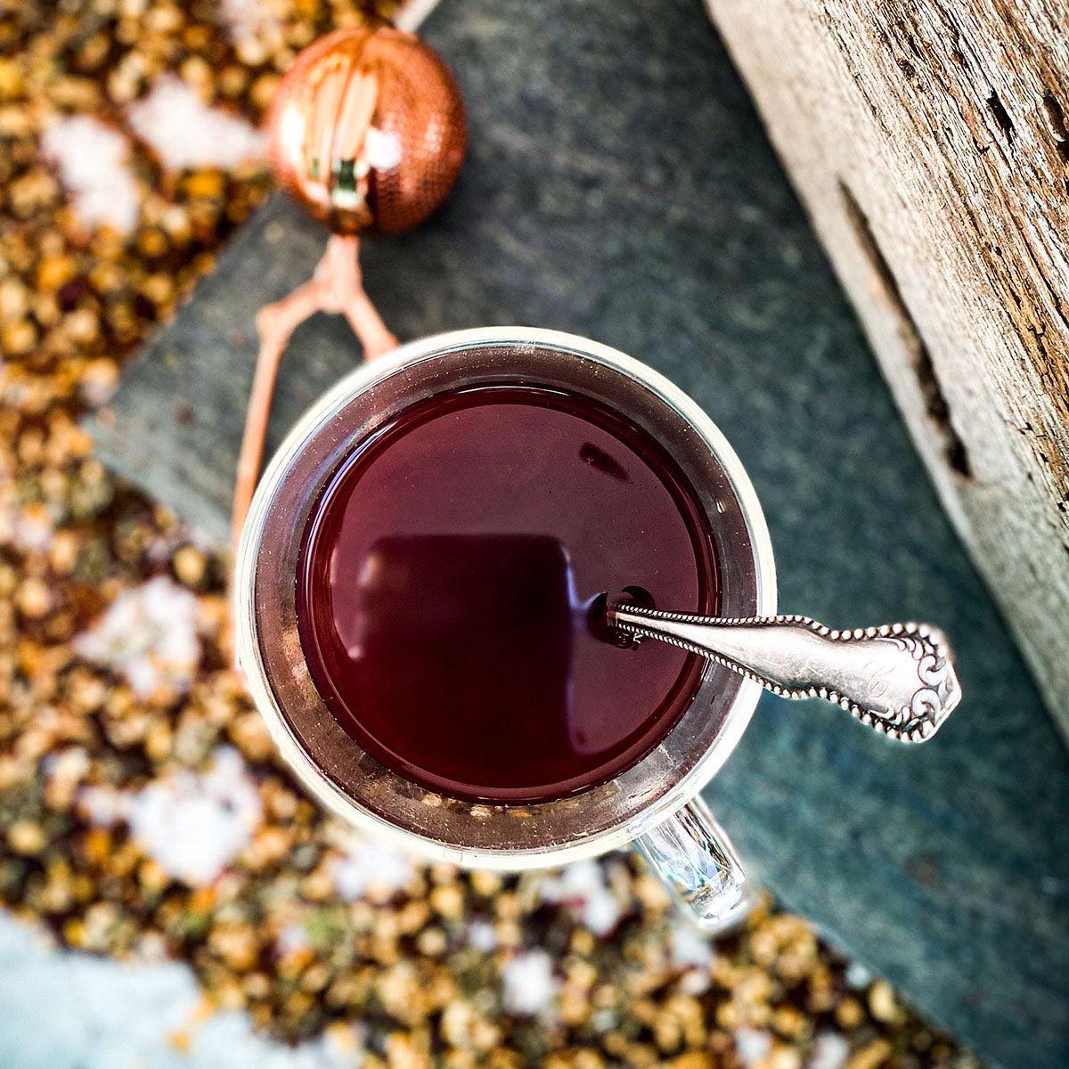 A brewed cup of Herban C tea with a stir spoon.