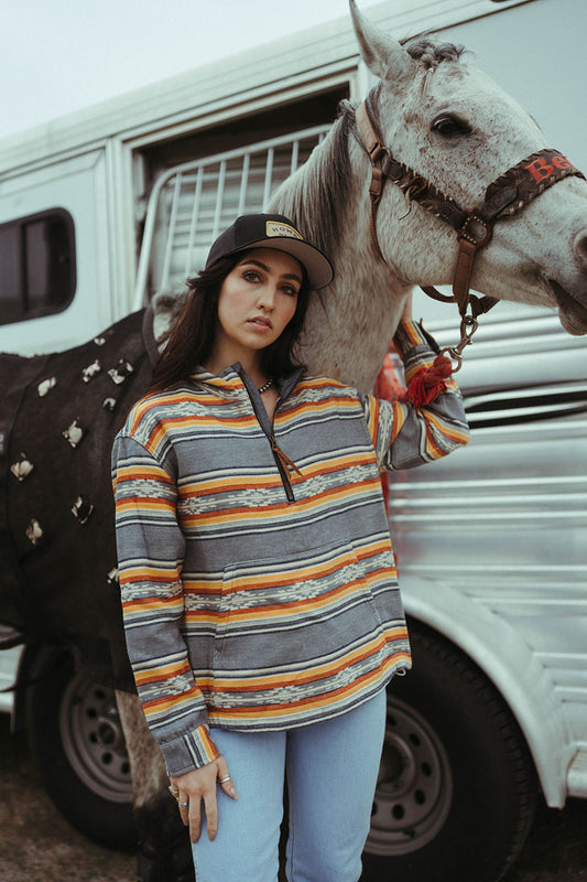 Woman standing beside horse and trailer modeling the Pendleton Quarter Zip Pullover. 
