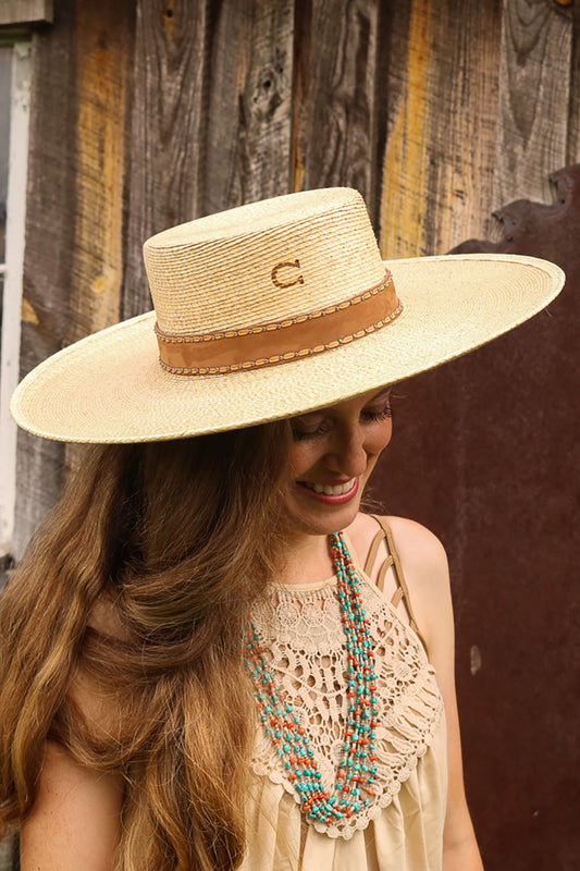 Woman wearing the Vaquera Cowgirl Hat by Charlie 1 Horse.  Straw style hat.