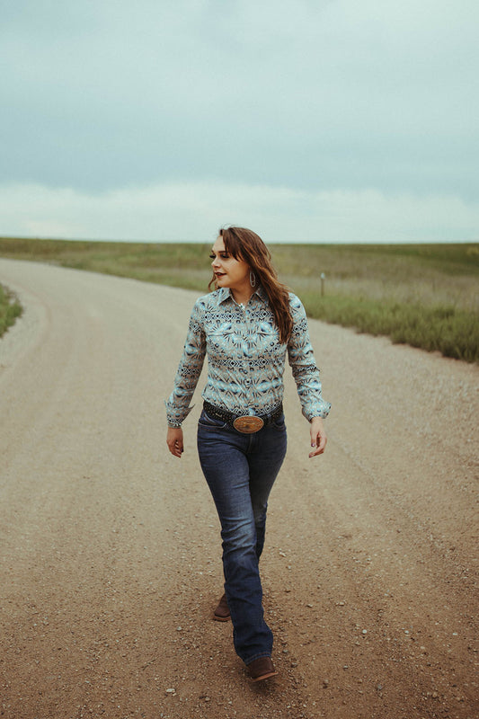 Woman walking down gravel road modeling the Women's Ultimate Riding Jean by Wrangler.  