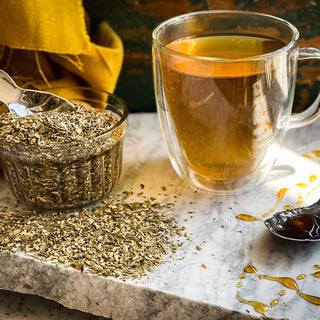 A brewed mug of Yerba Mate Tea sits next to a glass jar filled with the dried tea.