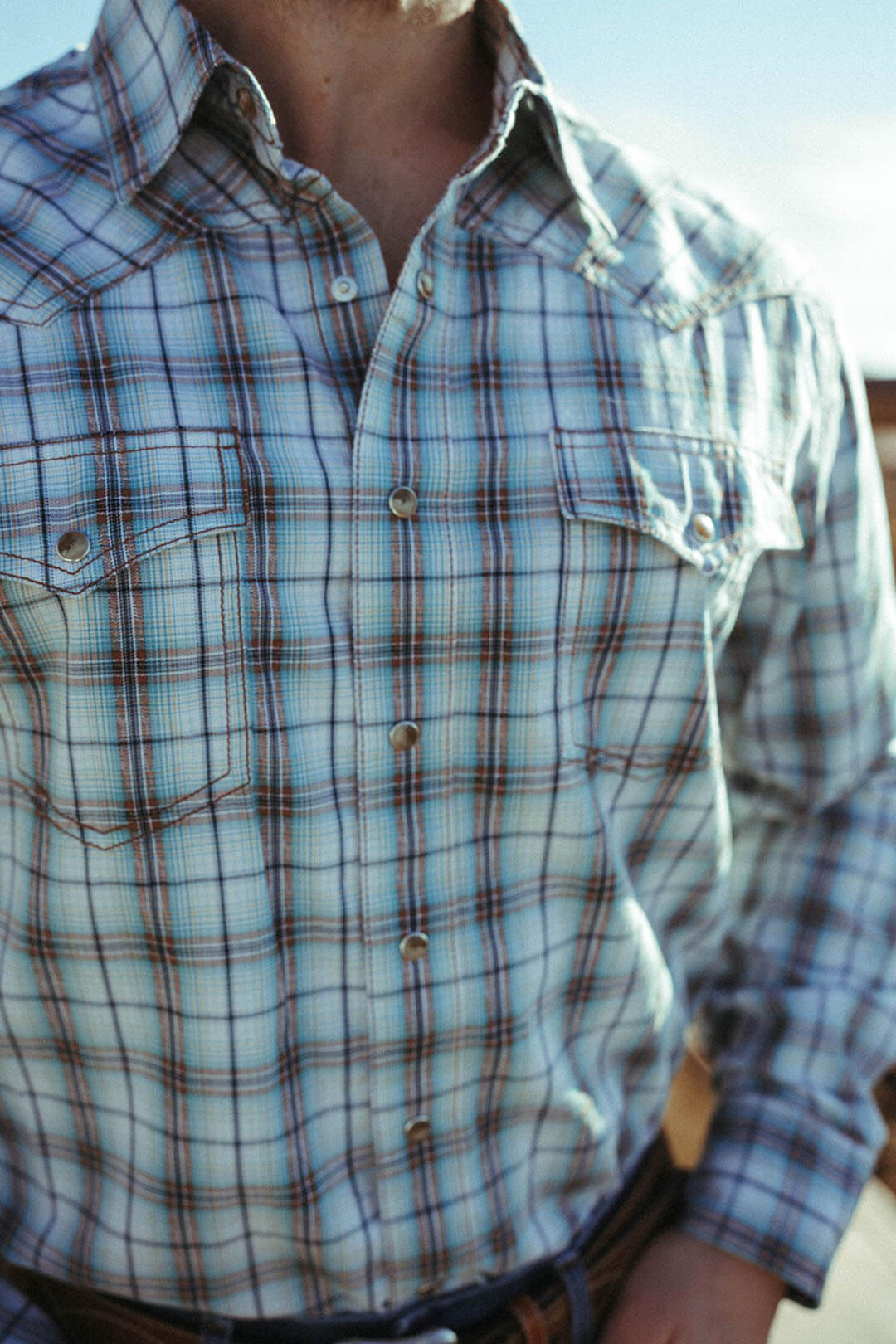 Close up image of the Wrangler Mens Aqua Retro Plaid Long Sleeve Shirt.  The shirt has pearl snaps and 2 chest pearl snap pockets. 