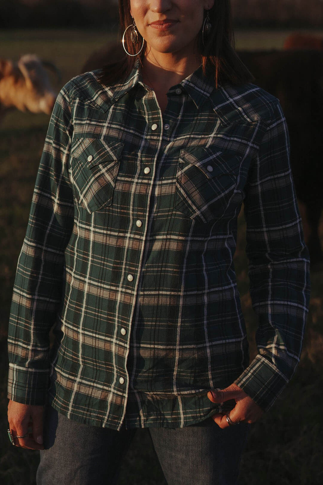 Close up picture of the wrangler retro plaid western pearl snap shirt.  The shirt features two front chest pockets and is collared with pearl snap cuff closures. 