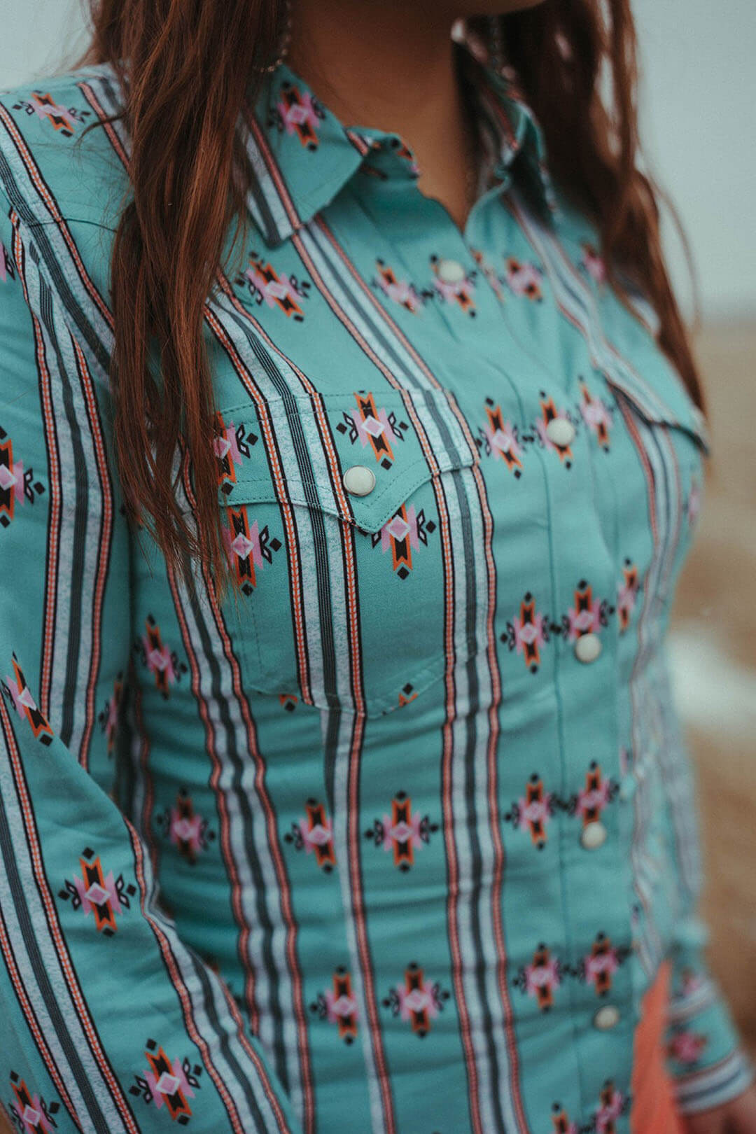 Close up image of the Wrangler Retro Green Aztec Top.  The top has to chest pockets with pearl snap closures.  