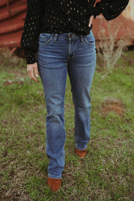 Woman modeling the front of the willow jeans-nellie wash bootcut by wrangler.  The jeans are zip fly/button closure with front pockets. 