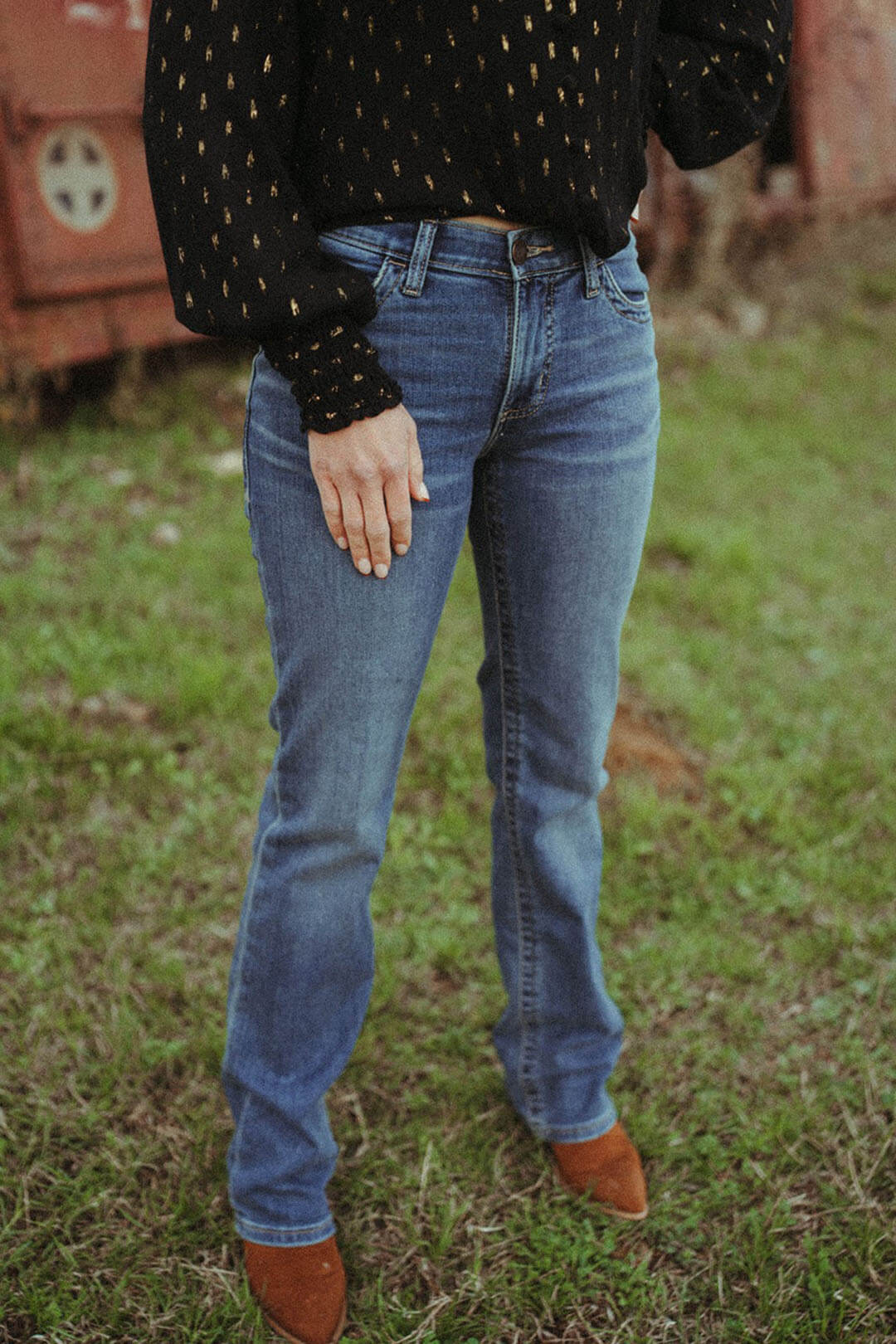 Woman modeling the willow nellie wash bootcut jean by wrangler.  The jeans have belt loops. 