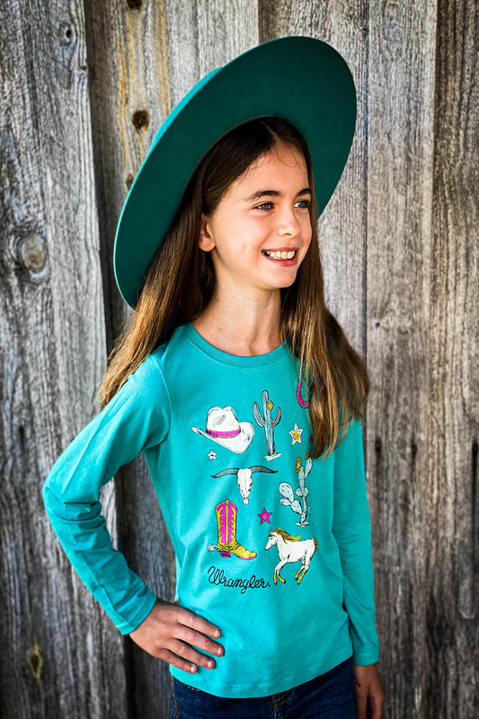 Girl wearing teal colored long sleeve shirt with cactus, horse, cowboy boots, horse shoe, cowboy hat with Wrangler