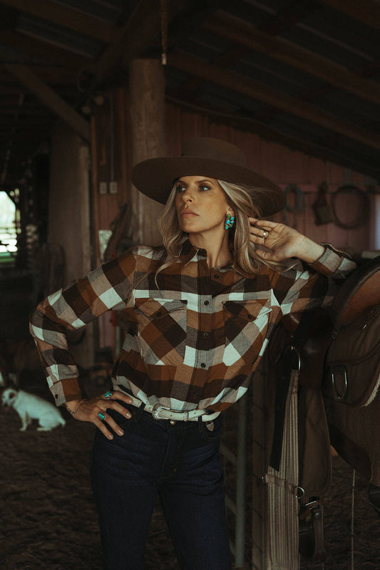 Woman modeling the soft madison flannel button up pendleton long sleeve shirt in brown and cream hues.  Features button chest pockets on each side. 